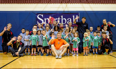 Sportball kids group waving at camera in gym