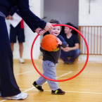 Boy throwing ball through hoop.