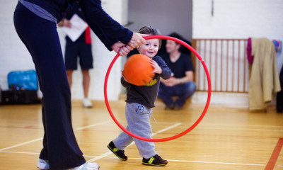 Boy throwing ball through hoop.