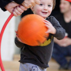 Child throwing ball through hoop.