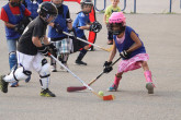 Children playing ball hockey outdoors.