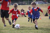 Young boys running on field during Sportball soccer class.